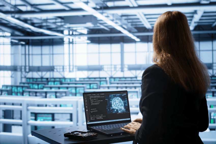 Person working in a high-tech factory using AI on a computer representing the technology industry